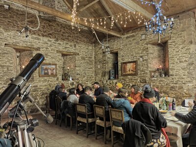 Group of people eating a meal in barn