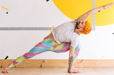 Yoga teacher stretched in Yoga pose wearing funky coloured yoga leggings 