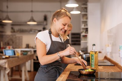 Guest fries chopped up onion in a pan