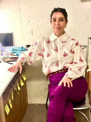 Host poses for a photo wearing shirt and vibrant pink trousers