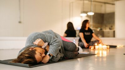 Close up on guest lying down on Yoga matt taking part in relaxing class 