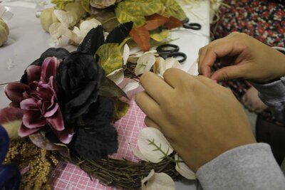 Close up on customer working on their autumn wreath 