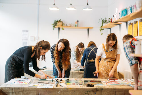 Print host Sophie Rae showing participants how to use rollers with hand-cut paper stencils.