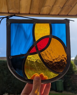 Hand-held stained glass panel glowing in sunlight