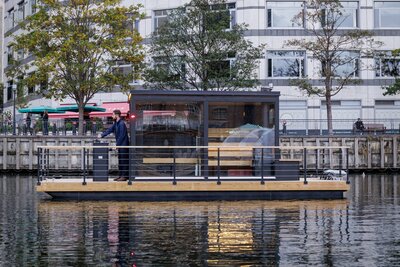 Charming canal float with modern glass cabin in the city