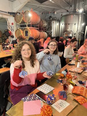 Joyful origami crafting at a lively brewery event