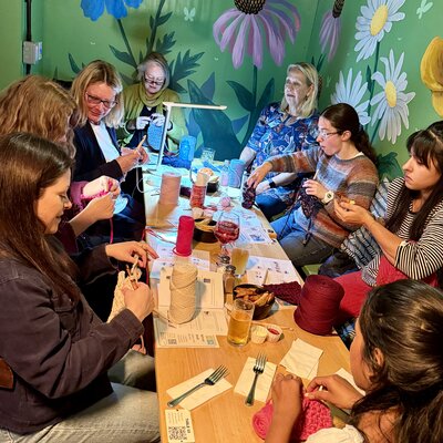 A cosy knitting group enjoying a creative evening together.
