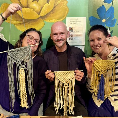 Joyful trio showcasing their crafty macramé creations!