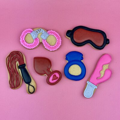 Naughty-themed biscuits on a pink backdrop - cheeky and playful!