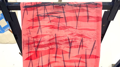 Vibrant abstract pattern on fabric drying on a frame