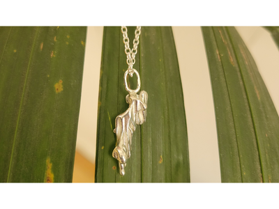 Delightful silver pendant on leafy backdrop