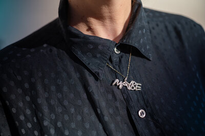 Charming &#39;Maybe&#39; necklace on polka-dot shirt