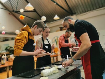 Cooking class fun with friendly instructor guiding eager participants.