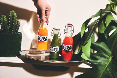 Colourful juices on a tray with tropical vibes