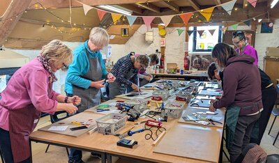 Guests enjoying a vibrant craft workshop under colourful bunting.