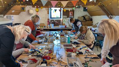 Group enjoying a cheerful stained glass workshop under colourful bunting.