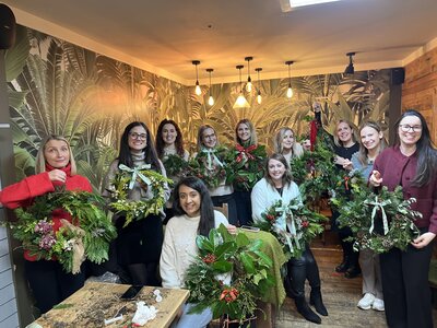 Joyful group crafting festive wreaths together