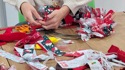 Crafting a festive wreath with colourful ribbons and holiday cheer