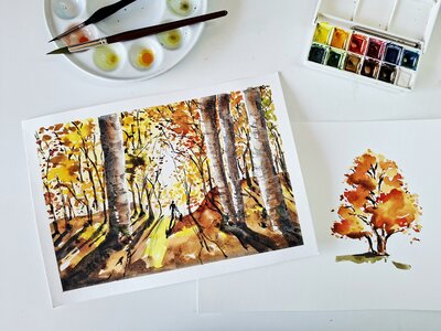 Autumn watercolour scene with vibrant trees and artists tools