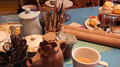 Craft table with paint brushes, vases & cupcakes on