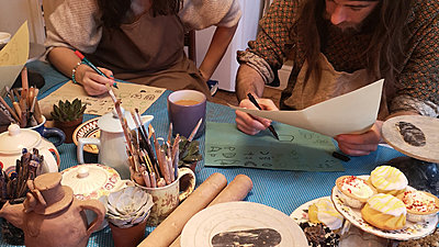 Tea Party guests sat by cupcakes draw onto paper
